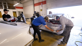 An instructor teaching a student during an auto collision repair class